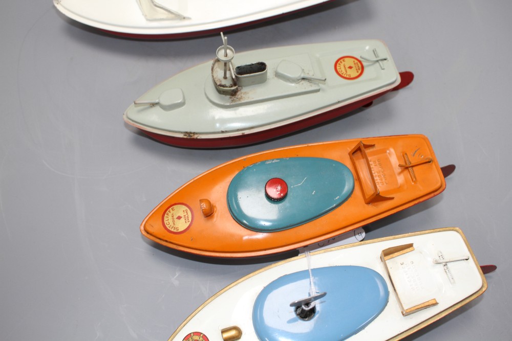 Four Sutcliffe enamelled metal model boats, comprising: two Racer I, both with clockwork, one with key, a Snappy cruiser and a Merlin